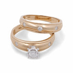 Two 14K Yellow Gold Bridal Woman Rings from Miral Jewelry are shown: one featuring a solitaire diamond in a prong setting, and the other adorned with five smaller diamonds embedded evenly around the band. Perfect as bridal jewelry.