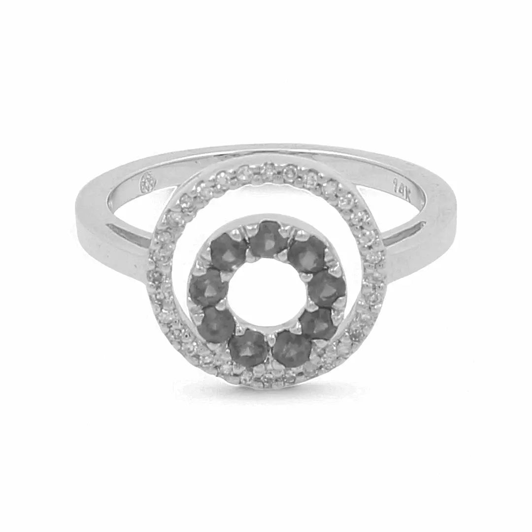 Introducing the "14K White Gold Fashion Diamond Woman Ring" by Miral Jewelry—a stunning silver ring with a circular design, accented with black stones at the center and encircled by smaller clear stones. It's perfect for anyone looking to make a fashion statement.