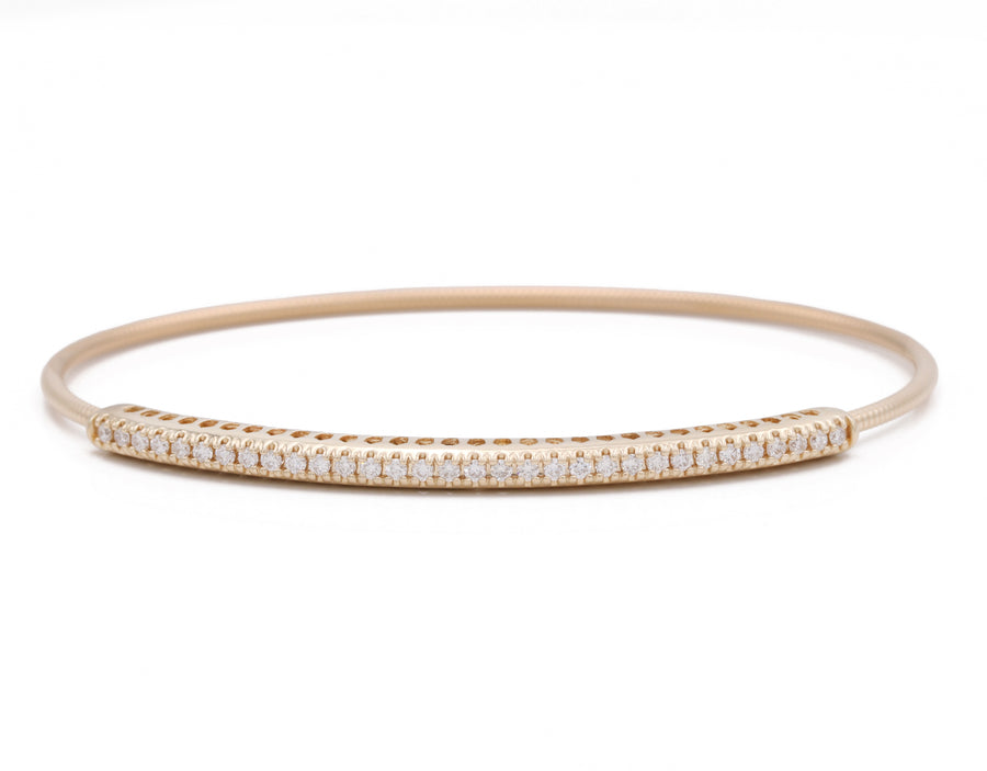 A Miral Jewelry yellow gold 14K bangle bracelet adorned with white diamonds.