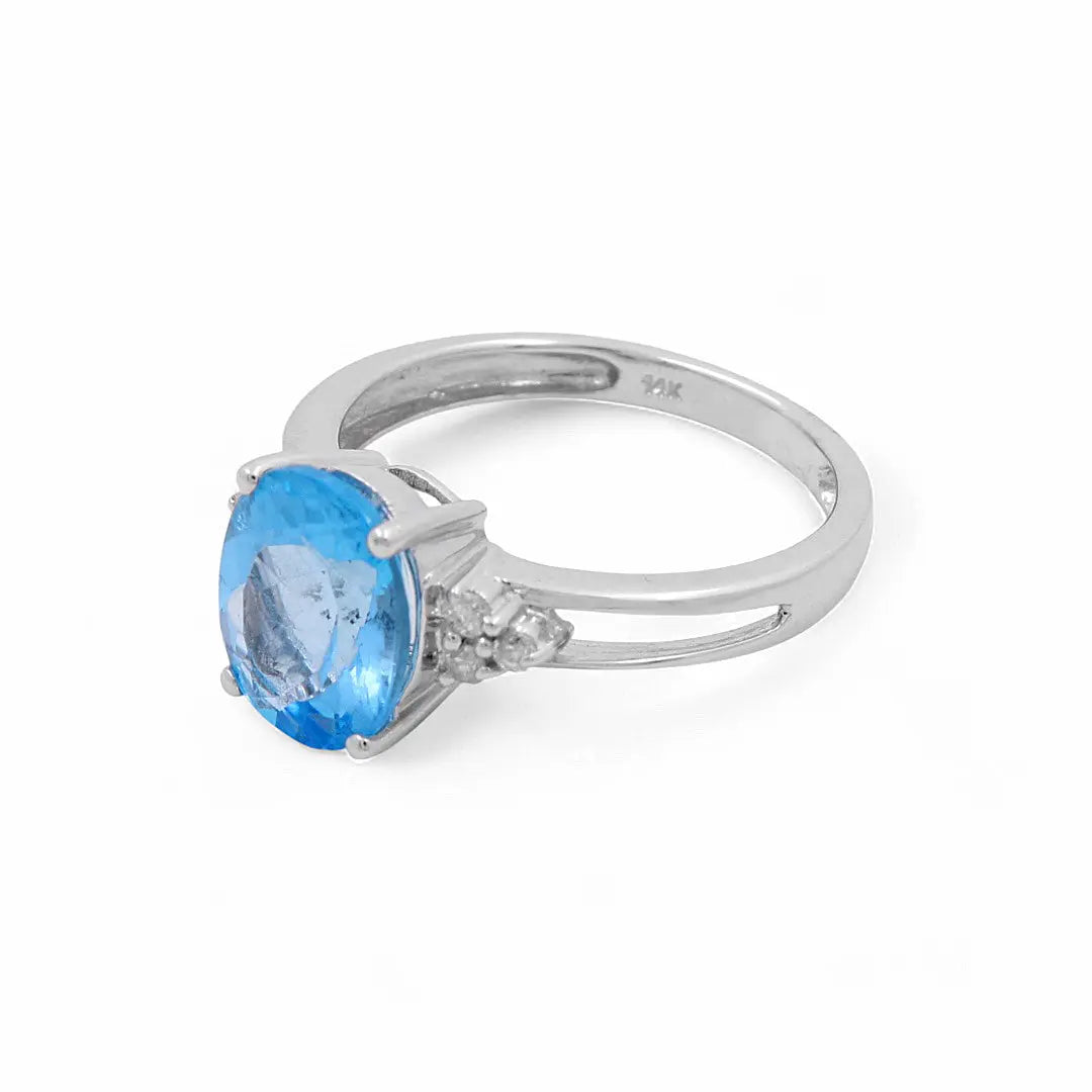 A 14K white gold ring featuring an oval blue topaz center stone, flanked by two smaller diamonds on each side, exemplifying contemporary diamond elegance from Miral Jewelry.