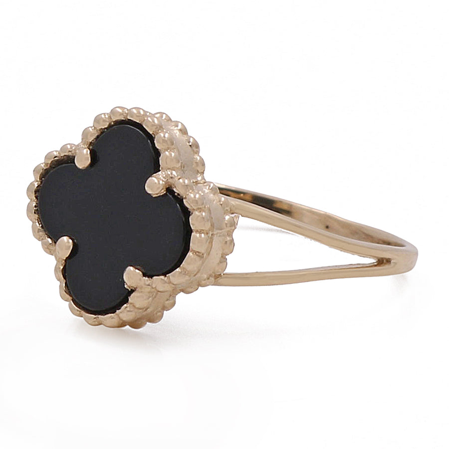 A Miral Jewelry fashion ring with a 14K yellow gold band and an onyx black stone in the center.