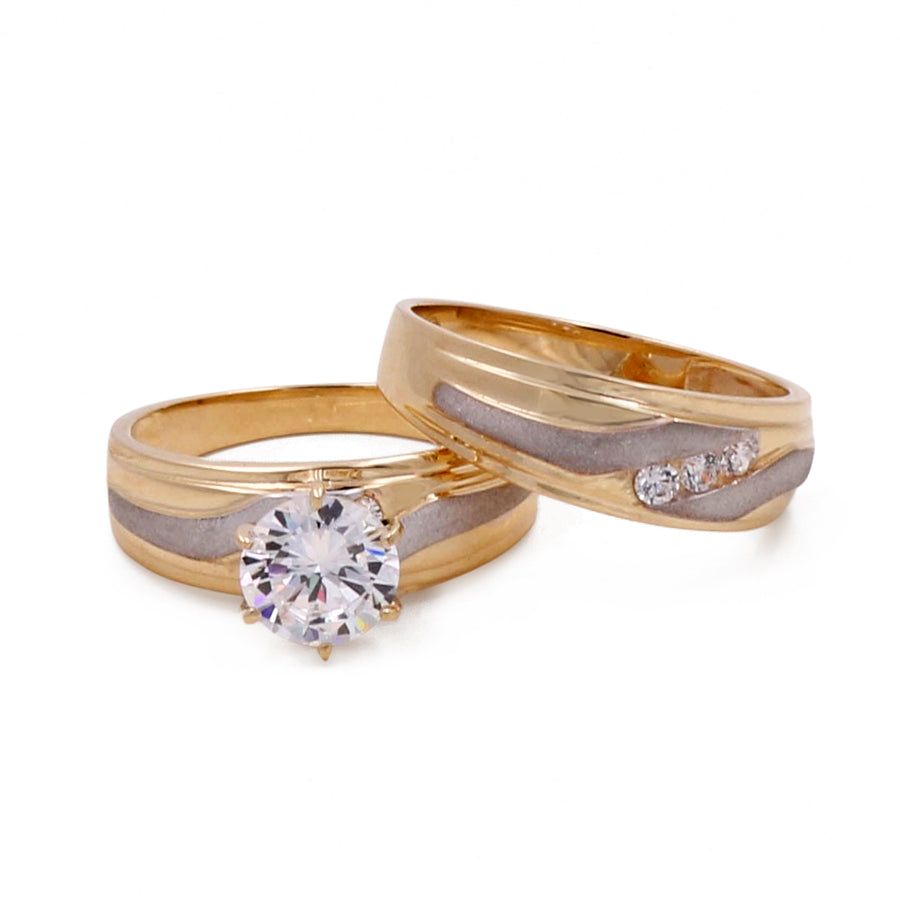 A pair of Miral Jewelry 14K yellow and white gold bridal set wedding bands, one with a solitaire cubic zirconia and the other with accent cubic zirconias.
