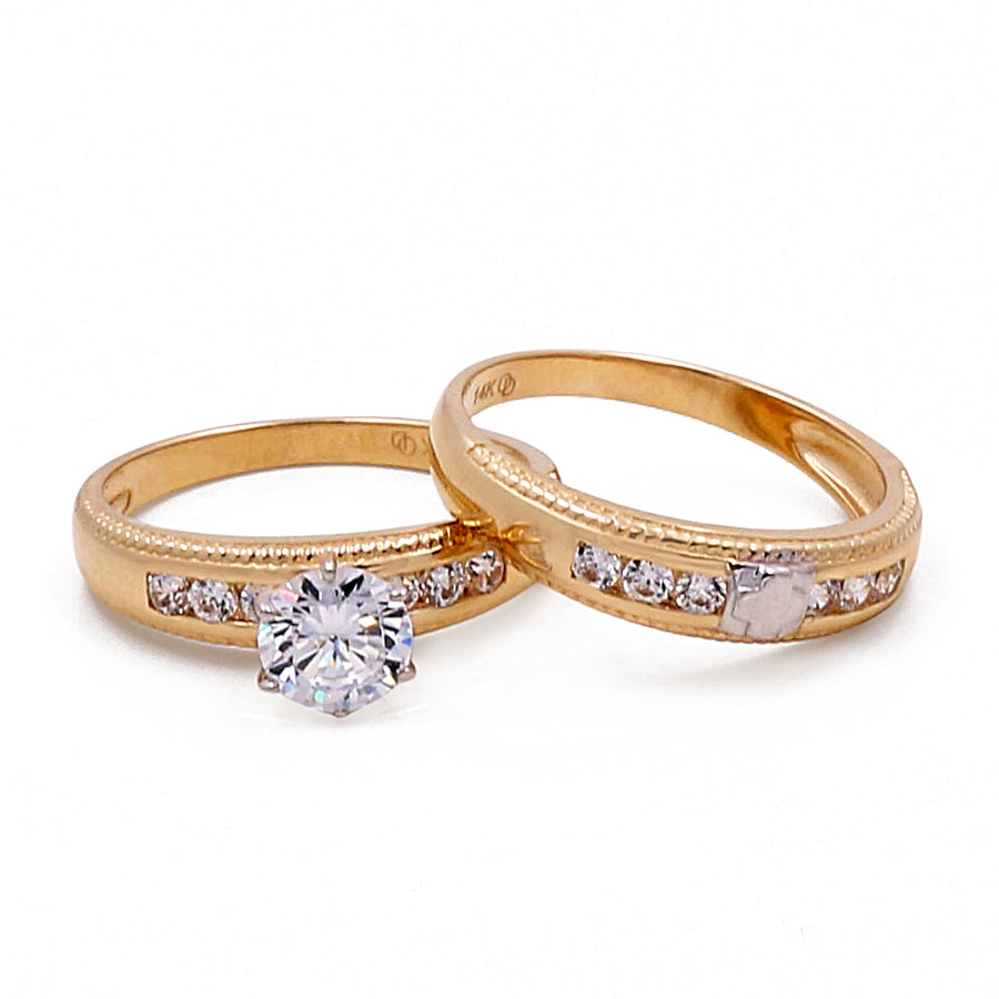 A pair of Miral Jewelry's 14K yellow gold engagement and wedding bridal set with cubic zirconias.