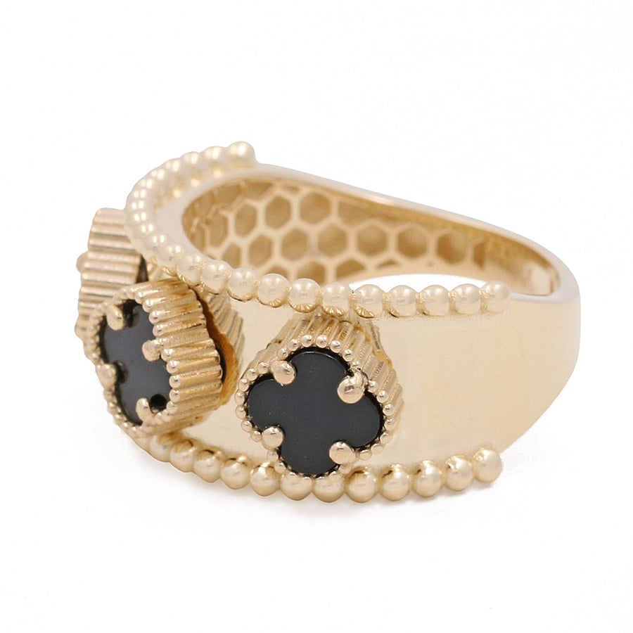 Miral Jewelry's 14K Yellow Gold Onyx Flowers Ring features a honeycomb design with black gem accents and a 14K yellow gold beaded trim.