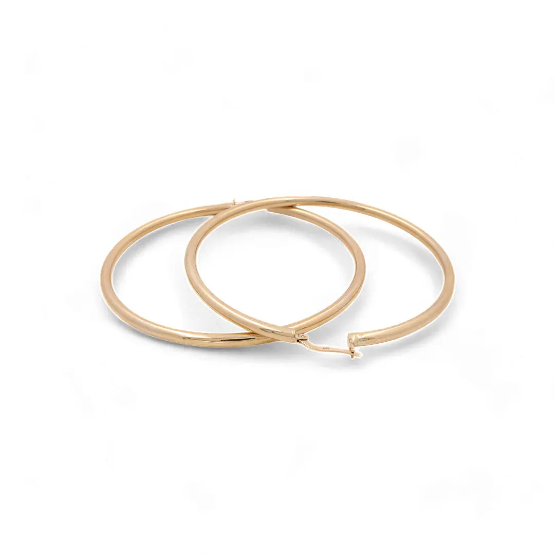 A pair of 14K Yellow Gold Large Hoop Women's Earrings from Miral Jewelry, featuring a straightforward latch closure, arranged side by side on a white background.