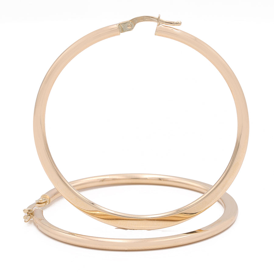 A pair of Miral Jewelry 14k Yellow Gold Medium Hoop Earrings on a white background.