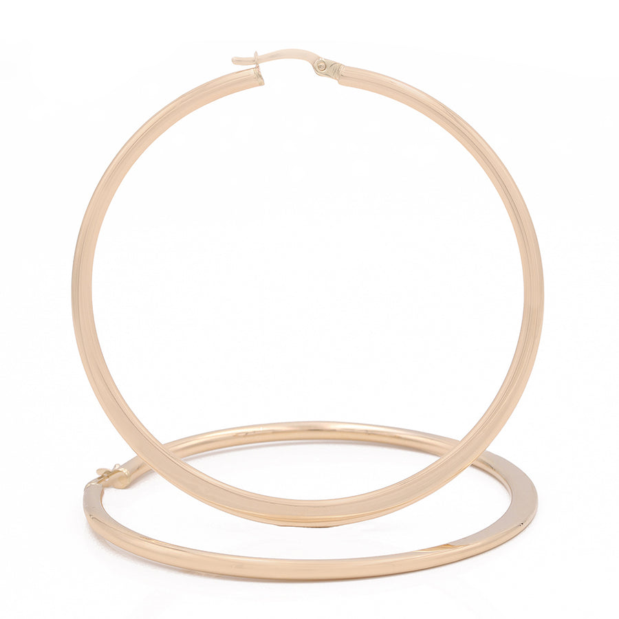 A pair of Miral Jewelry 14k Yellow Gold Large Hoop Earrings making a bold statement on a white background.
