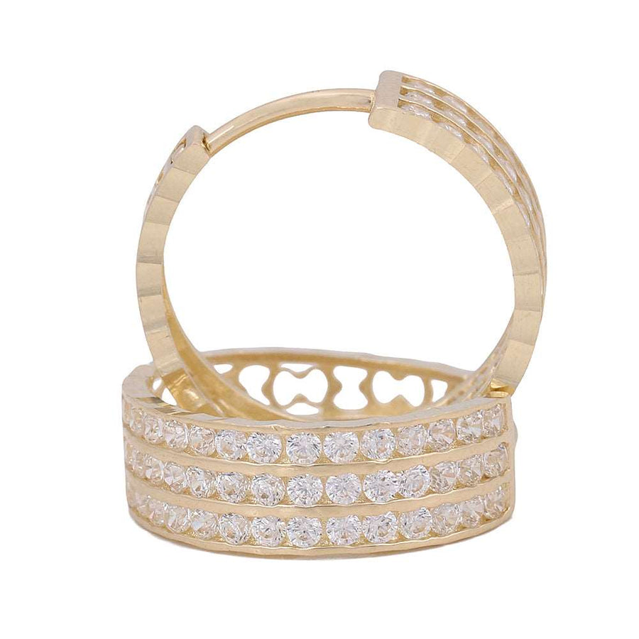 A pair of 10K Yellow Gold Hoop Earrings adorned with sparkling white diamonds, by Miral Jewelry.