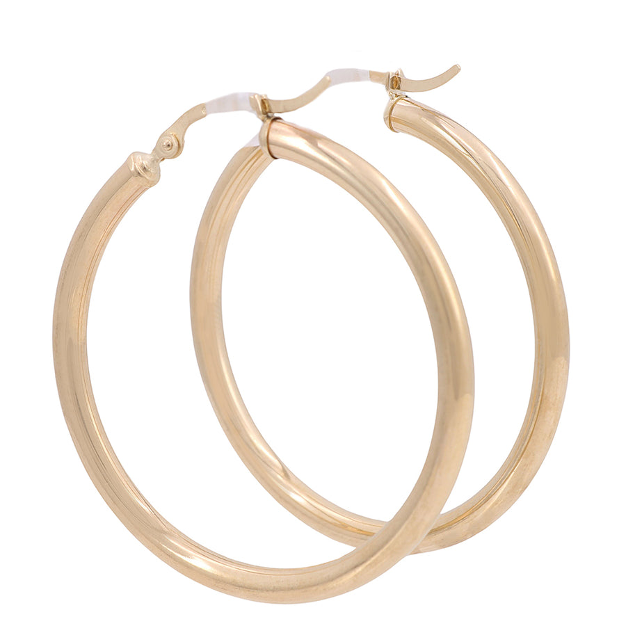 A pair of Miral Jewelry 10K Yellow Gold Hoop Earrings shining beautifully on a white background.