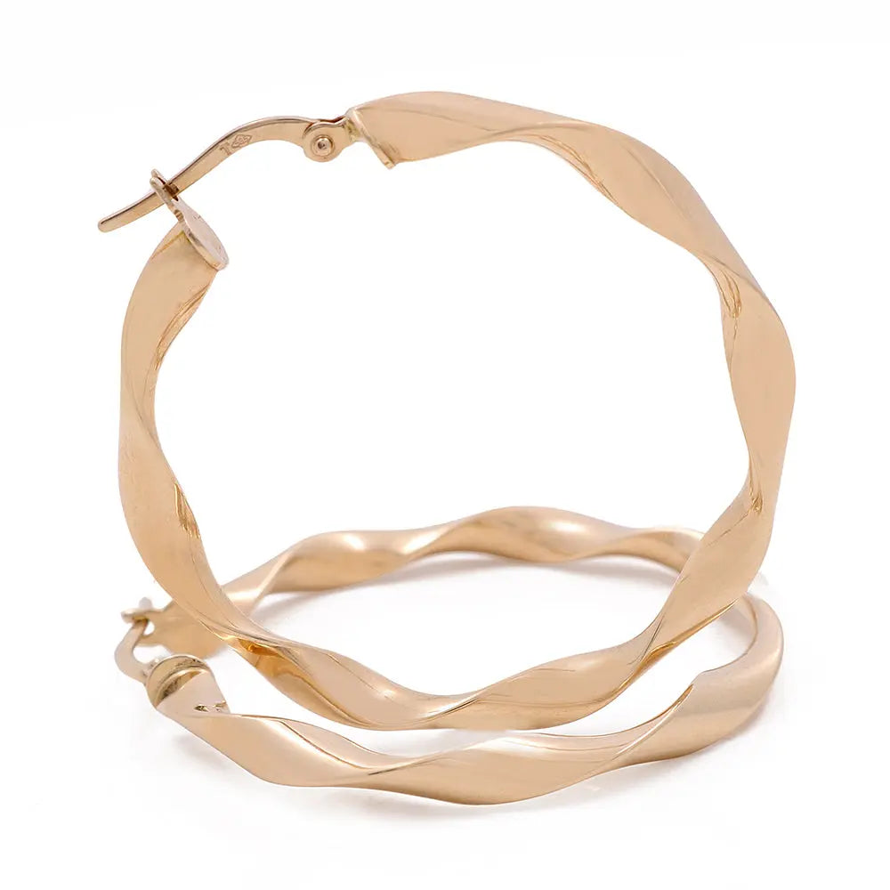 A pair of elegant gold plated hoop earrings crafted in 14K yellow gold by Miral Jewelry.