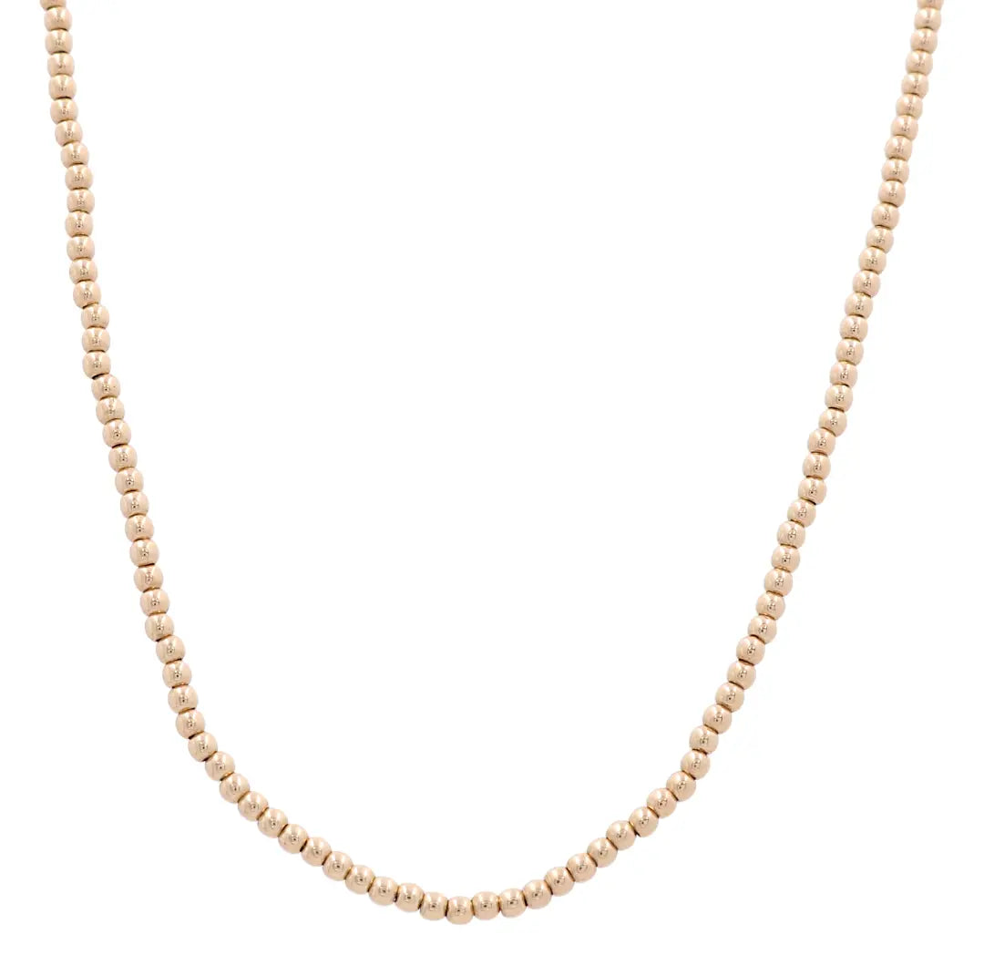 The 14k Yellow Gold Bead Chain from Miral Jewelry features uniformly sized round beads, forming a simple and elegant jewelry piece.