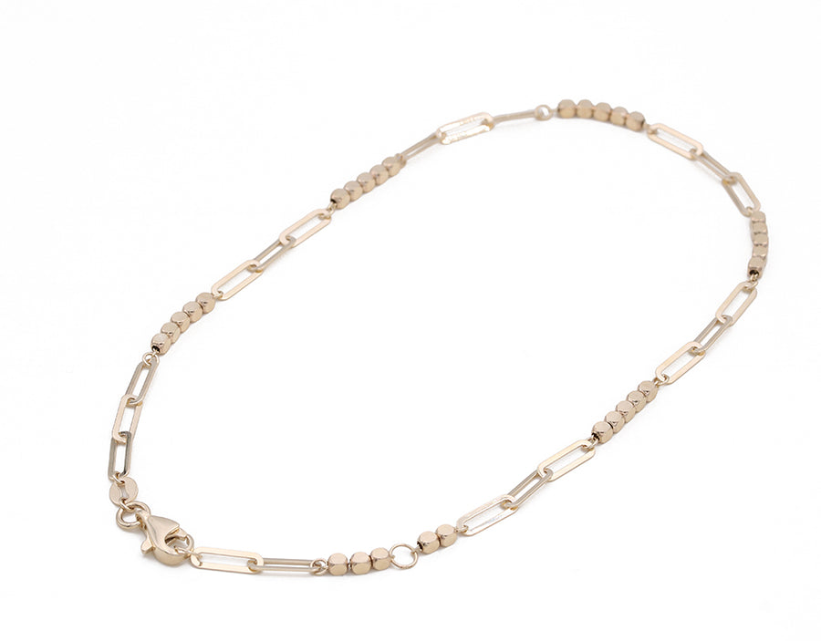 A 14K Yellow Gold Beads and Links Ankle Bracelet by Miral Jewelry with a gold-plated clasp.