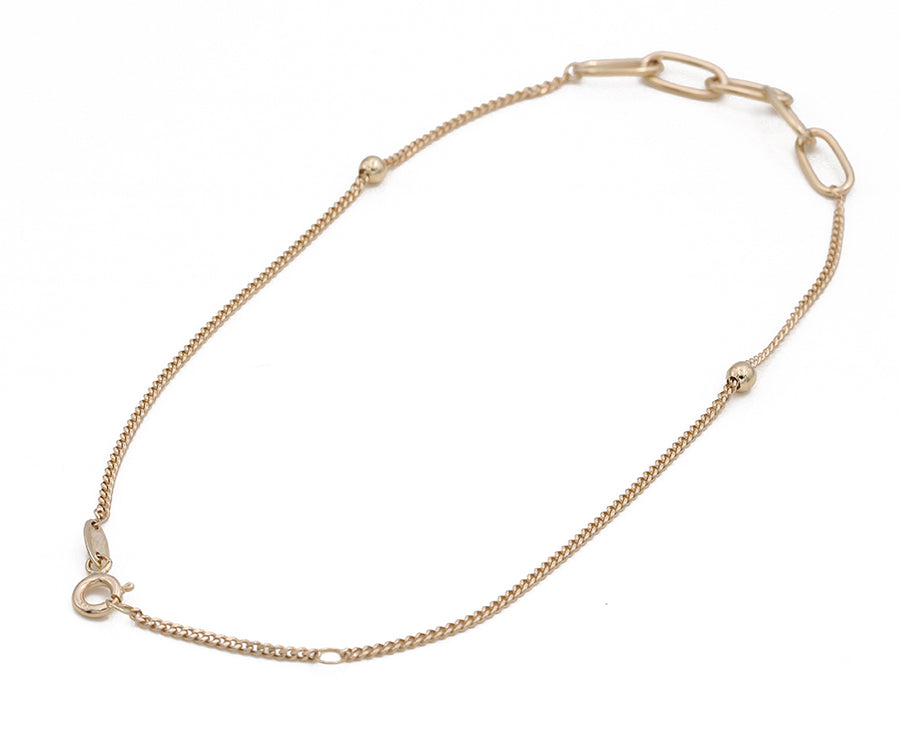 A 14K Yellow Gold Chain and Links ankle bracelet with a clasp from Miral Jewelry.