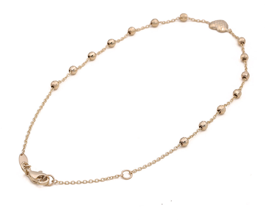 An accessory adorned with Miral Jewelry's 14K Yellow Gold Beads and Hearts Ankle Bracelet and a clasp.