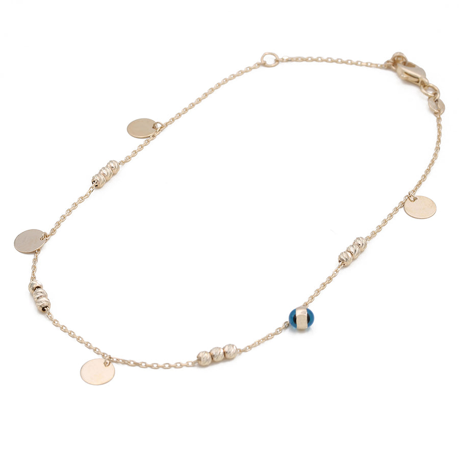 A 14K Yellow Gold Links Ankle Bracelet with blue and white beads by Miral Jewelry.