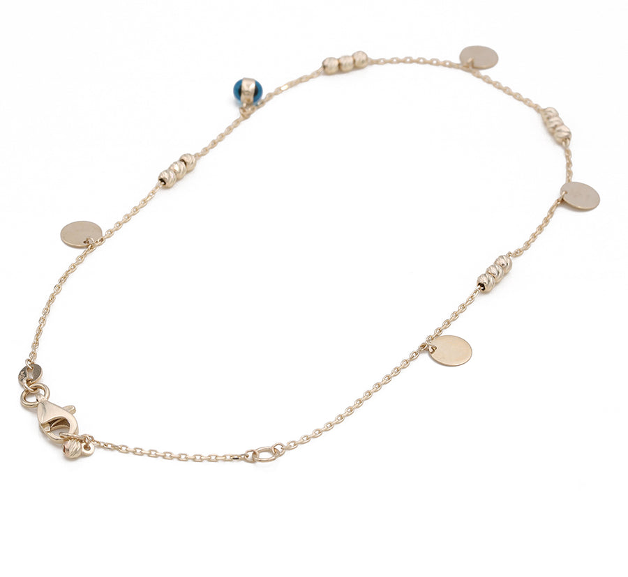A Miral Jewelry 14K Yellow Gold Links Ankle Bracelet with a blue and gold charm.