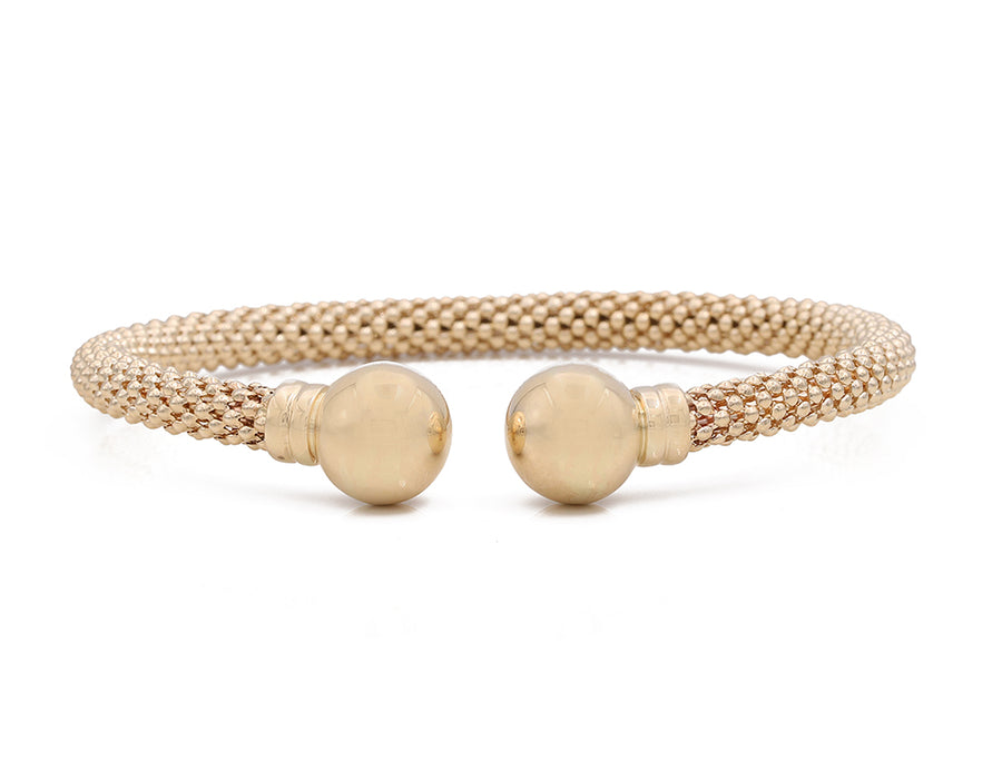 A Miral Jewelry 14K yellow gold mesh bracelet with two fashion balls on it.