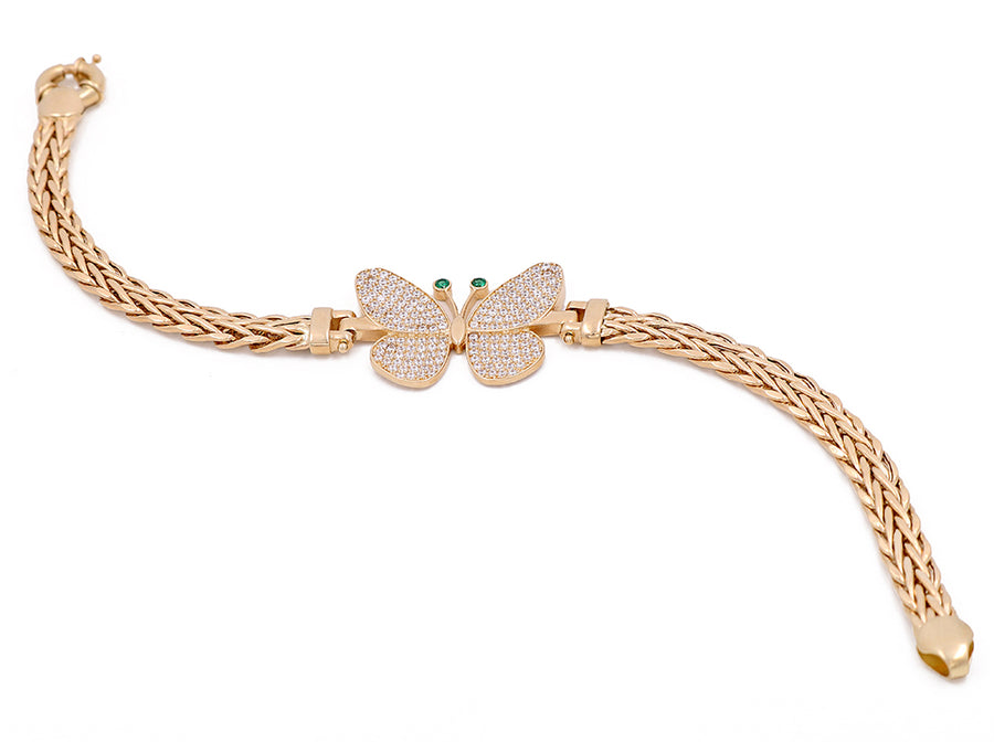 A Miral Jewelry 14K Yellow Gold Butterfly Bracelet adorned with Green Stones and Cubic Zirconias.