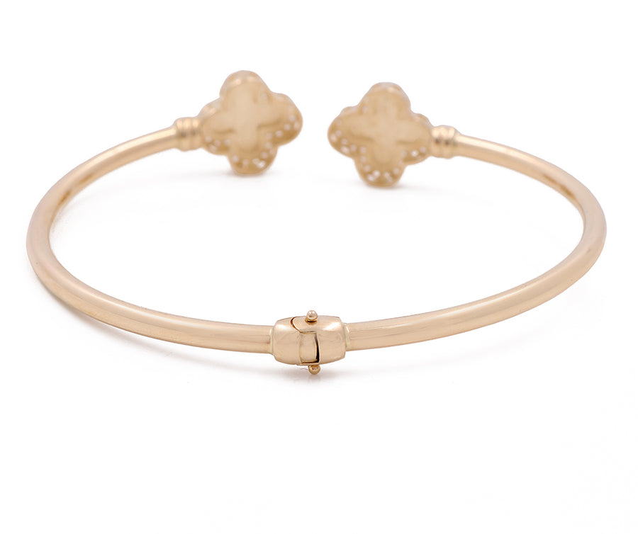 A Miral Jewelry 14K Yellow Gold Fashion Flower Bangle with Cubic Zirconias plated bangle bracelet adorned with two Fashion Flower gold- plated charms.