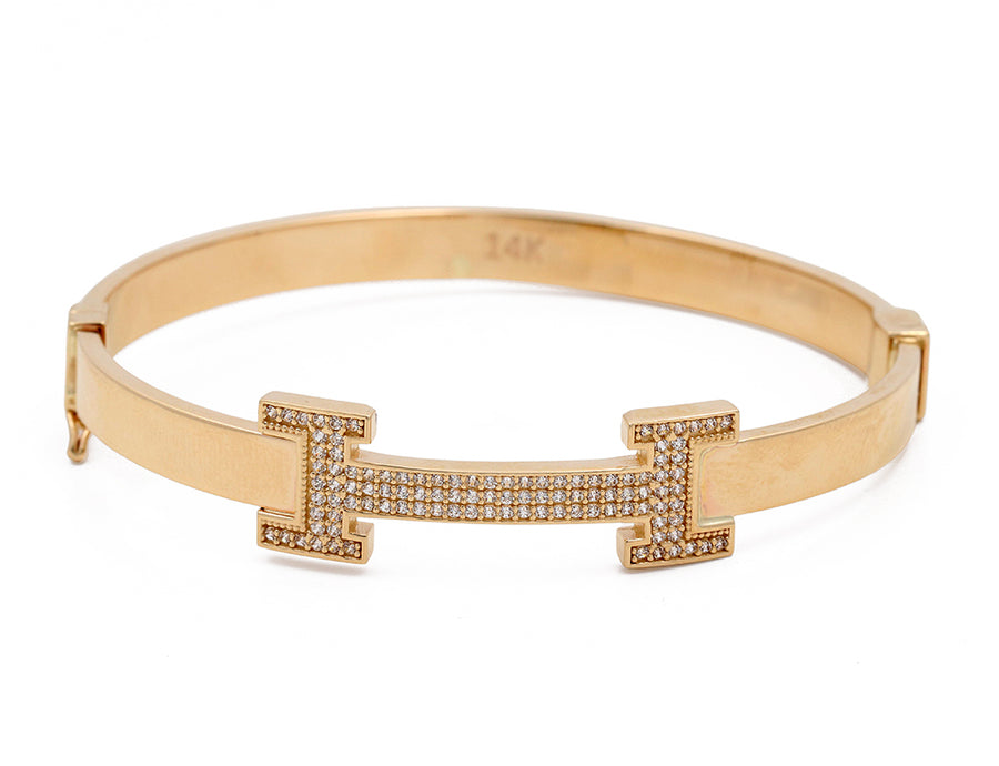 Miral Jewelry's 14K Yellow Gold Fashion Bracelet with Cubic Zirconias, featuring a pavé t-bar design, isolated on a white background.