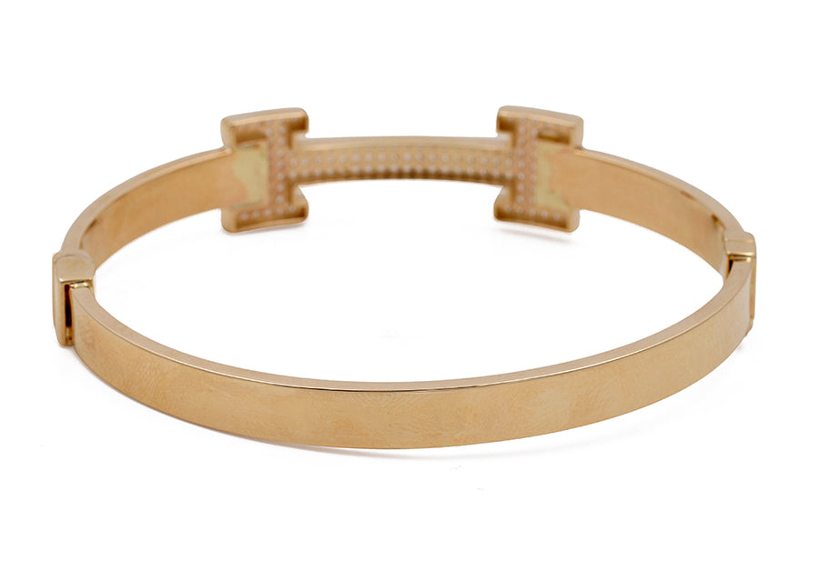 14K Yellow Gold Fashion Bracelet with Cubic Zirconias by Miral Jewelry, with a minimalist open band design and a detailed bridge connection, isolated on a white background.