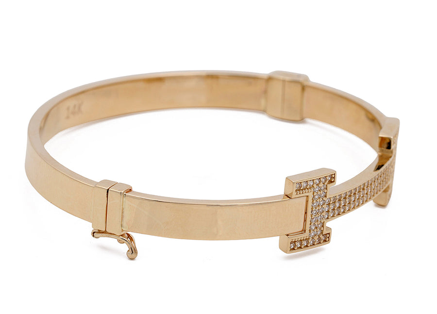 Miral Jewelry's 14K Yellow Gold Fashion Bracelet with a hinge and a decorative clasp featuring Cubic Zirconias, displayed on a white background.