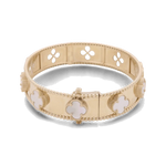 A 14K yellow gold fashion flower women's bracelet from Miral Jewelry, adorned with mother-of-pearl clover-shaped embellishments and a clasp closure, featuring a design of quatrefoil cut-outs along the band.