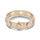 A 14K yellow gold fashion flower women's bracelet from Miral Jewelry, adorned with mother-of-pearl clover-shaped embellishments and a clasp closure, featuring a design of quatrefoil cut-outs along the band.