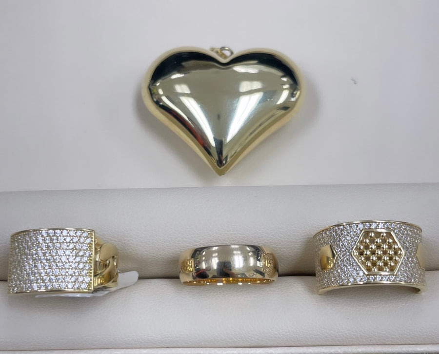 A Miral Jewelry gold ring set with a 14k yellow gold heart-shaped pendant.