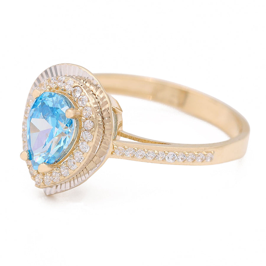 A Miral Jewelry 14K Yellow Gold Fashion Ring featuring a blue tear drop topaz and accent diamonds.