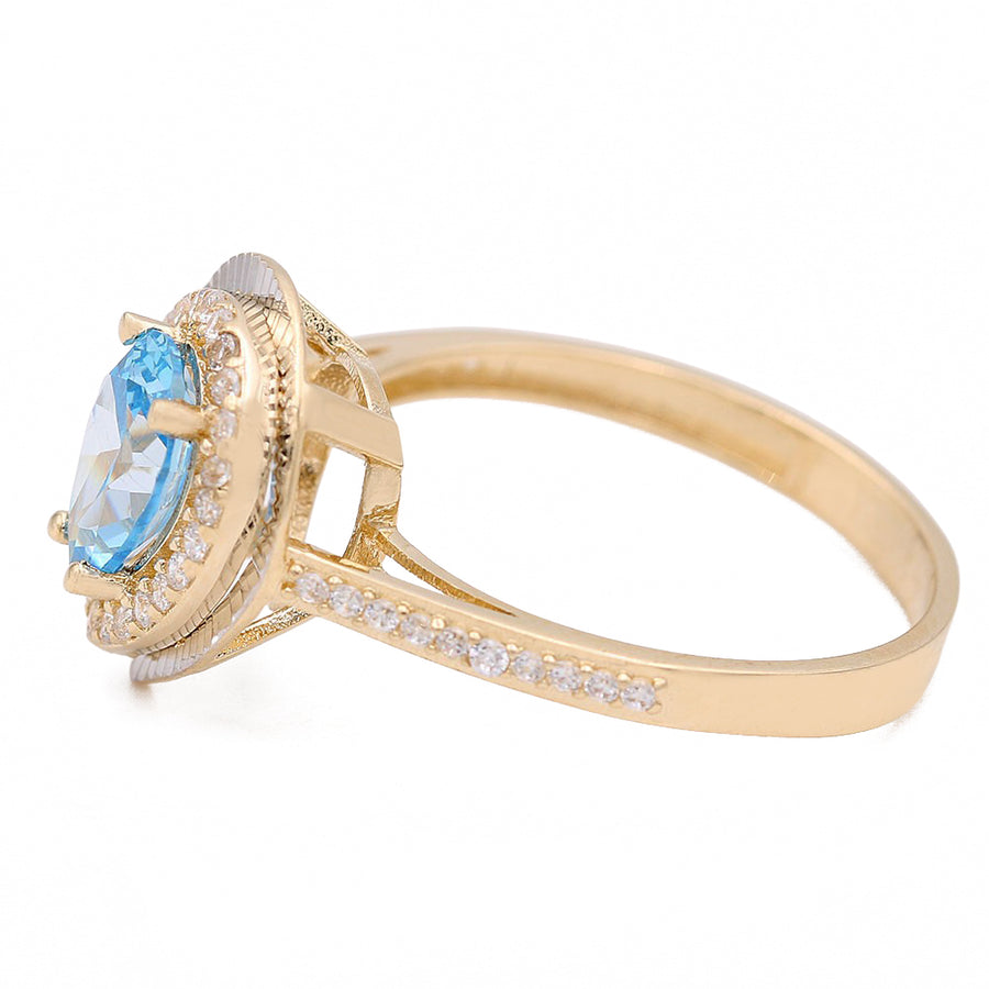This Miral Jewelry fashion ring features a stunning blue tear drop topaz surrounded by diamonds, all set in 14K yellow gold.
