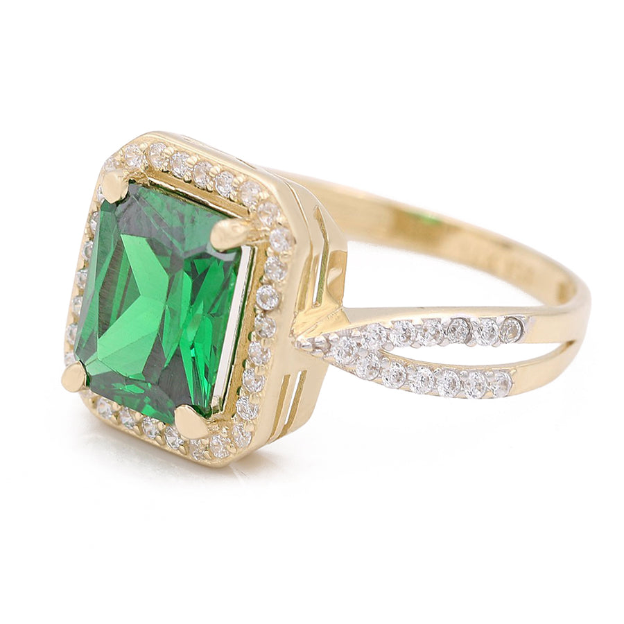 A Miral Jewelry 14K yellow gold fashion ring with a green center stone, featuring emeralds and diamonds.
