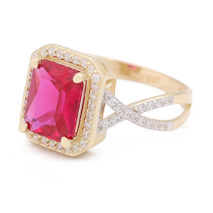 A Miral Jewelry fashion ring featuring an emerald cut ruby set in 14K yellow gold, with diamonds accentuating the pink center stone.