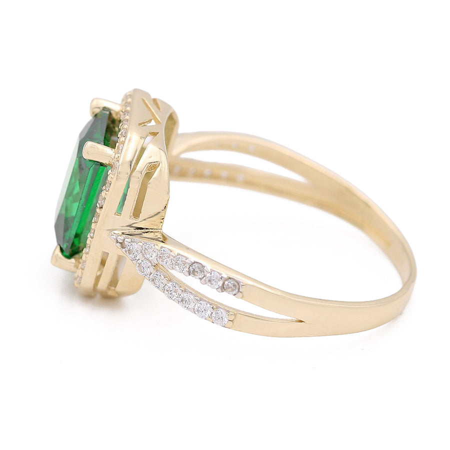 This Miral Jewelry 14K Yellow Gold Fashion Ring with Green Center Stone and Cubic Zirconias features a stunning emerald center stone, complemented by diamond accents.