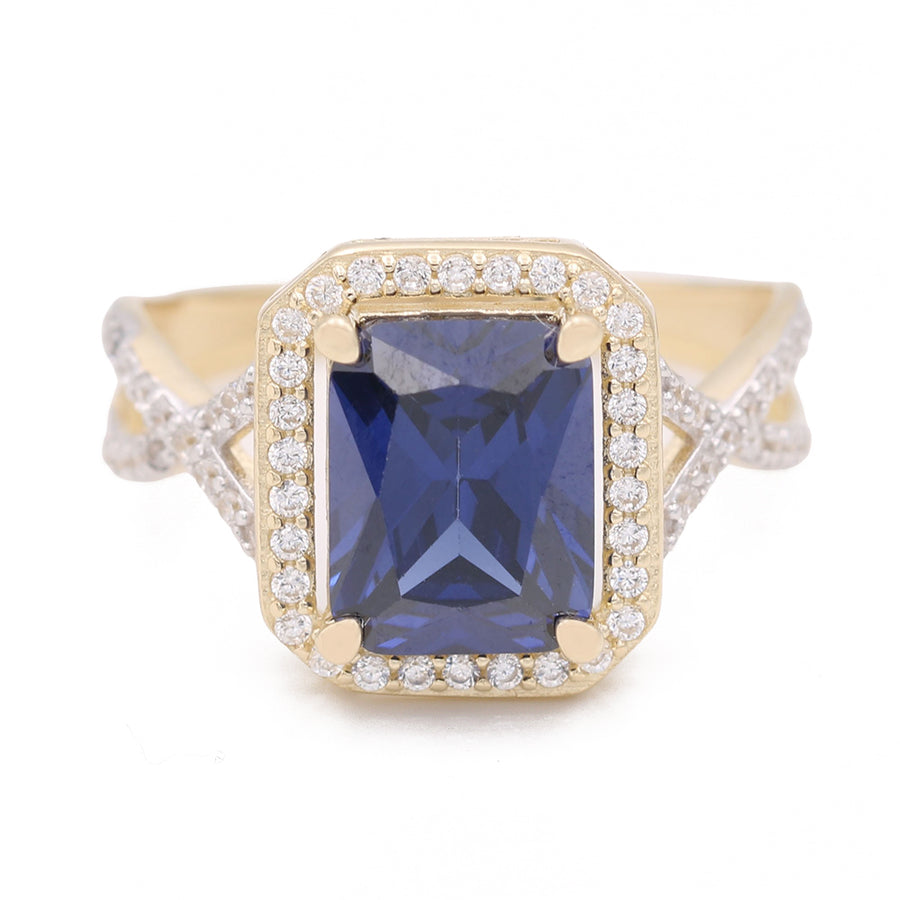 A Miral Jewelry fashion ring with a blue sapphire center stone set in 14K yellow gold.