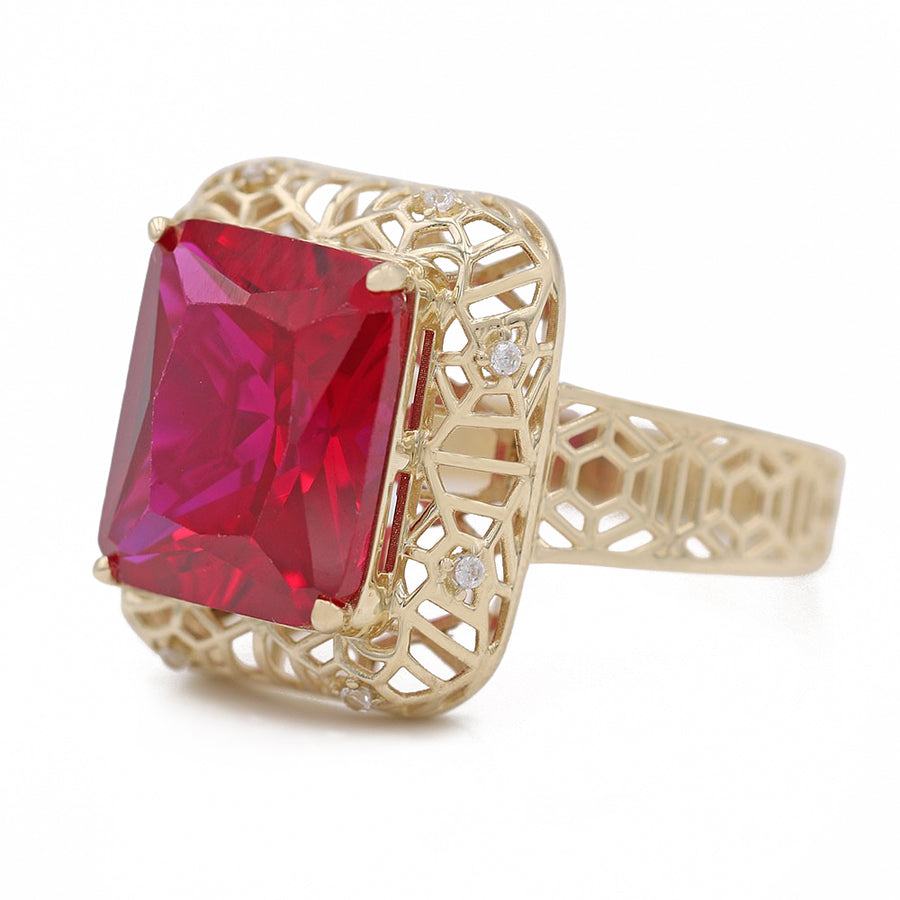 A Miral Jewelry fashion ring with a red center stone, made of 14K yellow gold and adorned with diamonds.