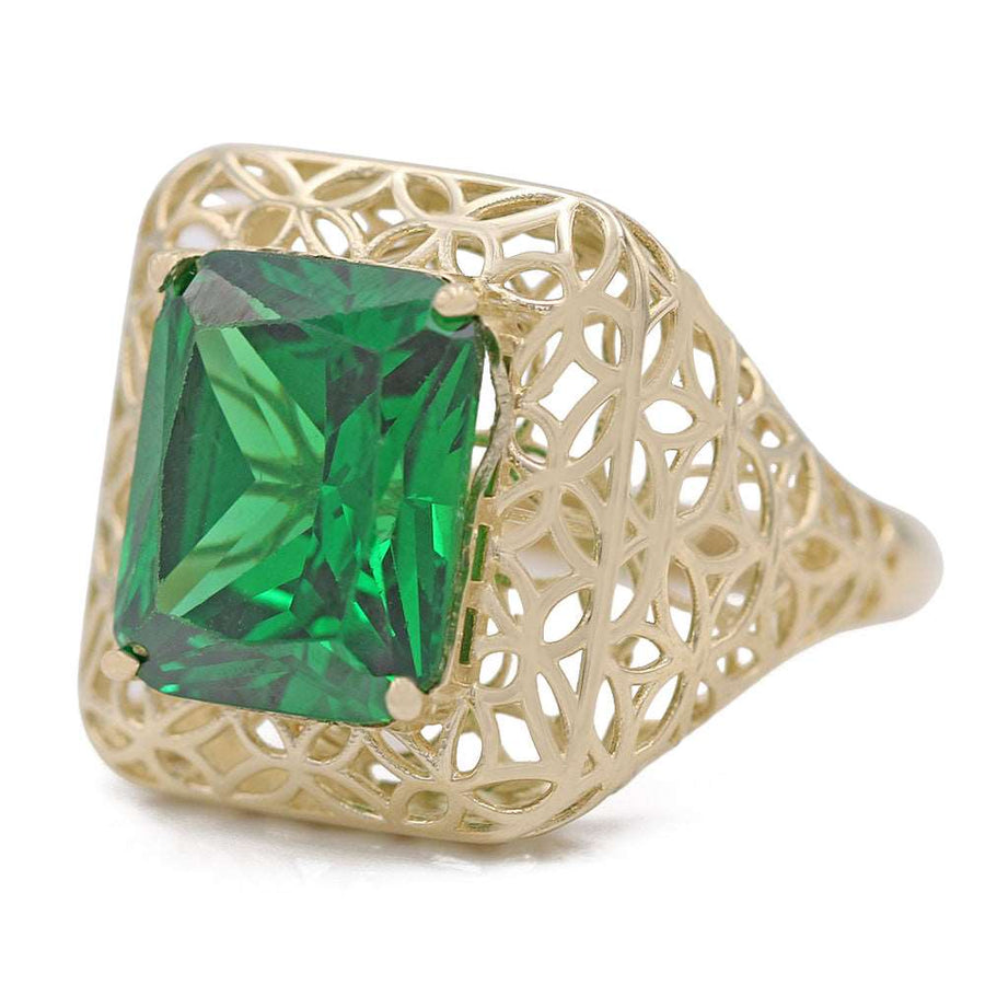 A Miral Jewelry 14K Yellow Gold Fashion Ring with Green Center Stone and Cubic Zirconias in an emerald cut.