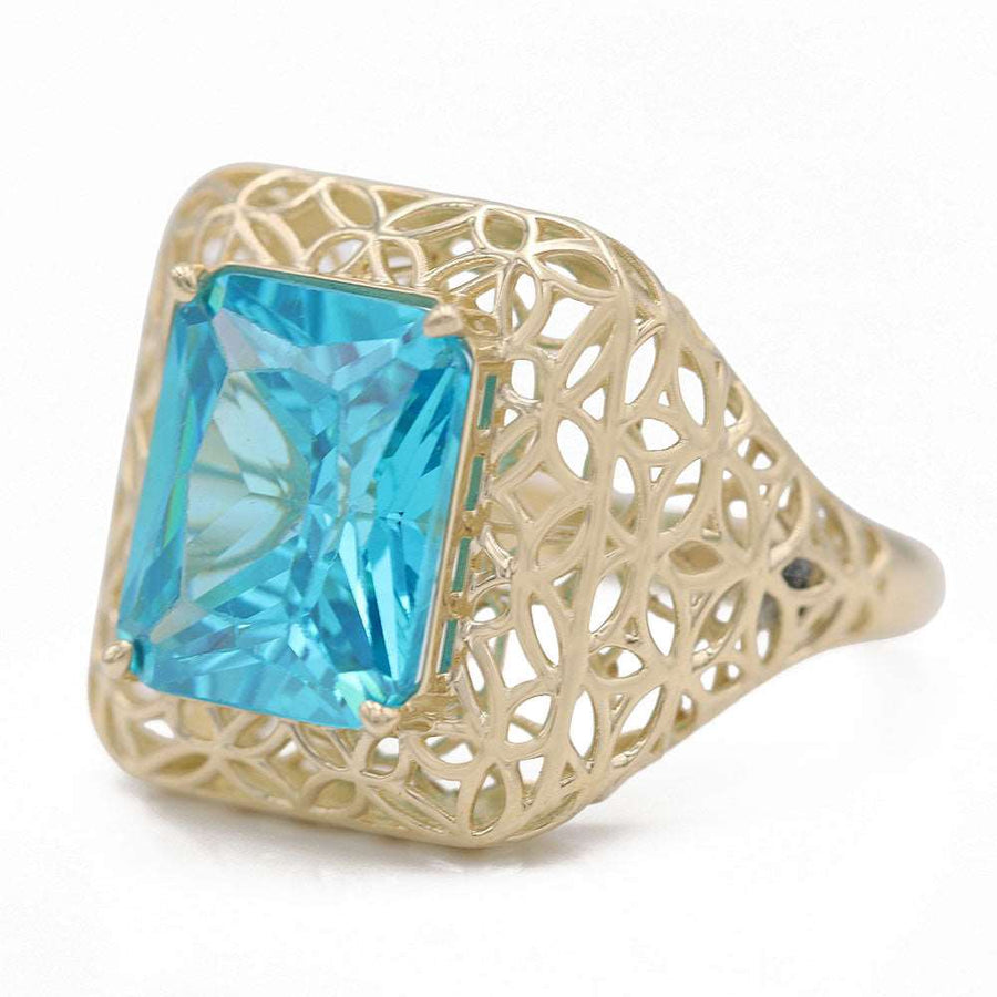 A Miral Jewelry 14K Yellow Gold Fashion Ring with Blue Center Stone and Cubic Zirconias.