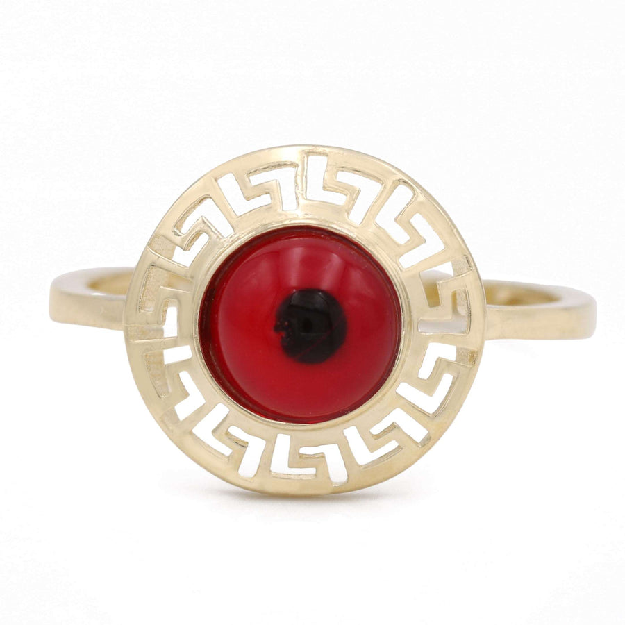 A Miral Jewelry fashion-forward 14K yellow gold ring adorned with a striking evil eye design in red.