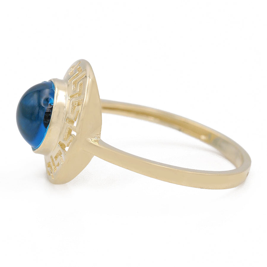 A 14K Yellow Gold Fashion Blue Evil Eye Ring by Miral Jewelry with a blue topaz stone.