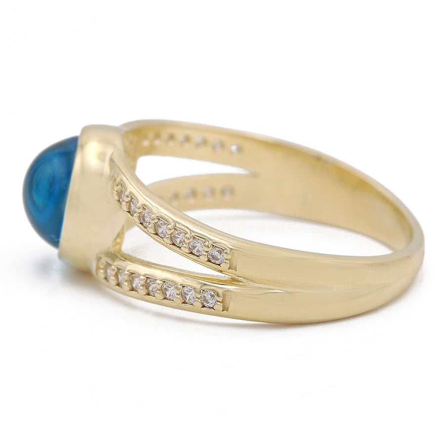 A Miral Jewelry 14K Yellow Gold Fashion Blue Evil Eye Ring with Cubic Zirconias with a blue topaz and diamonds.