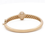 A 14K Yellow Gold Fashion Flower Women's Mother of Pearl Bracelet by Miral Jewelry featuring a decorative pattern on its inner side and a central oval gemstone setting, enhanced with a subtle fashion flower design.