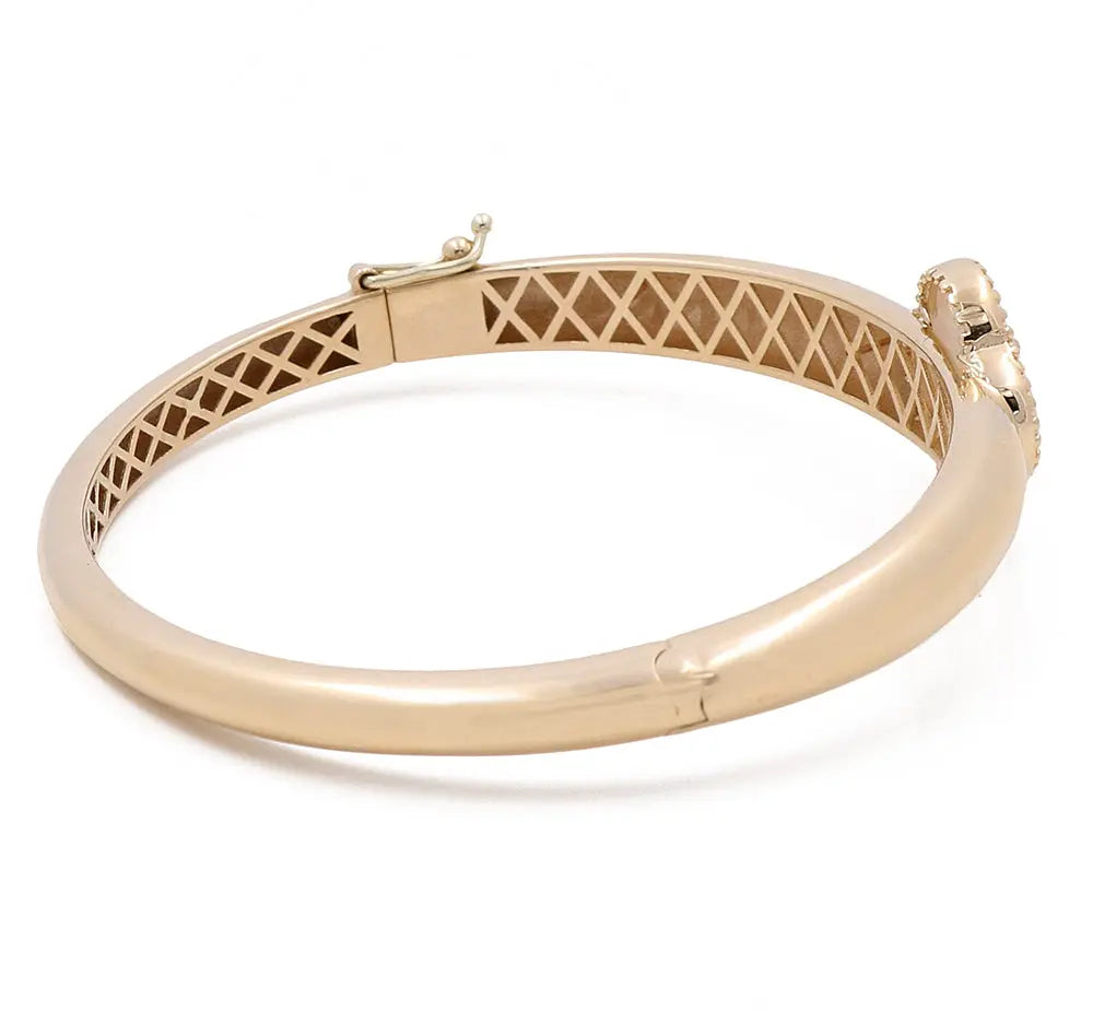 Gold bangle with a clasp and lattice inner design, featuring a small decorative element near the clasp. This Miral Jewelry 14K Yellow Gold Fashion Flower Women's Mother of Pearl Bracelet showcases an exquisite fashion flower design that adds a touch of elegance to any outfit.