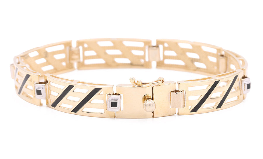 A Miral Jewelry 14K Yellow Gold Fashion Links and Color Stones bracelet with black and white stripes.