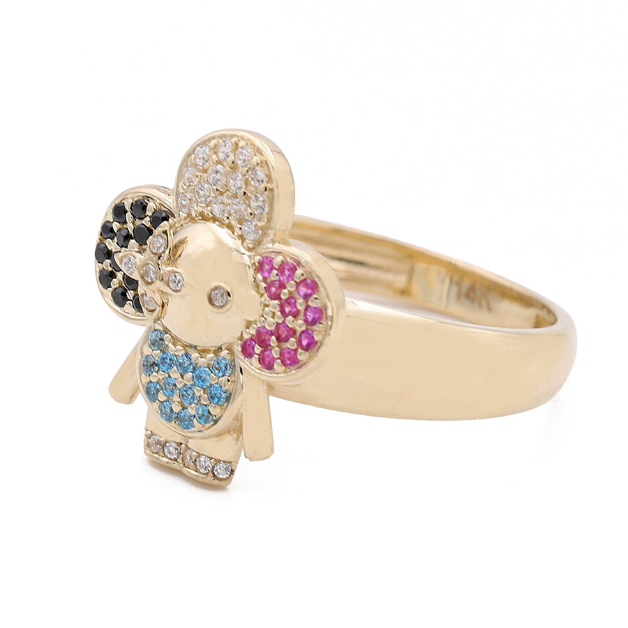 A fashionable Miral Jewelry flower-shaped gold ring featuring a little girl in the center. Made with 14K yellow gold and adorned with vibrant color stones.