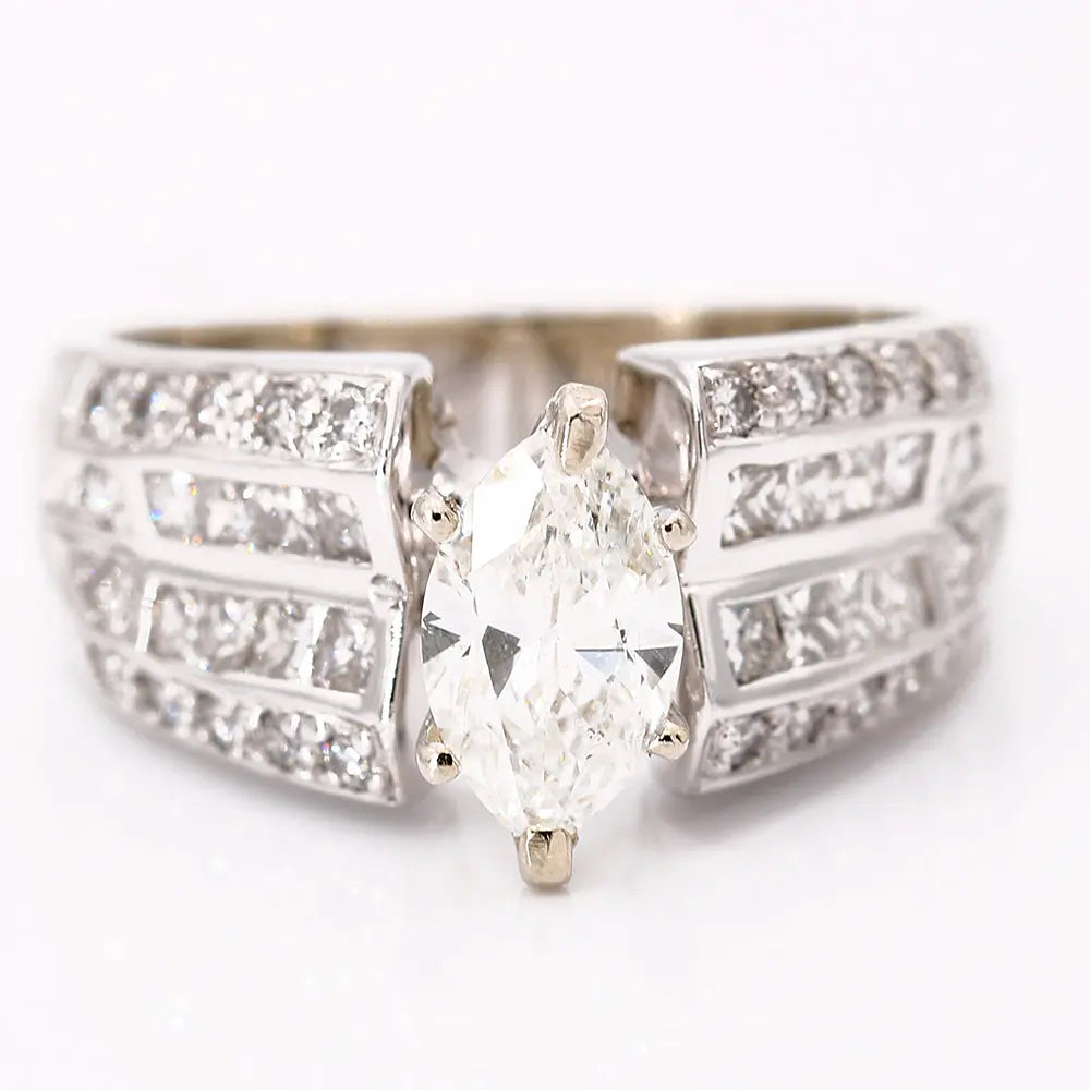 A timeless bridal set boasting a marquise-cut, near-colorless diamond ring with a wide band featuring multiple rows of smaller diamonds, all set in gleaming white metal, possibly white gold or platinum. This White 14 Karat Contemporary Diamond Bridal Set by Miral Jewelry exudes elegance and sophistication.