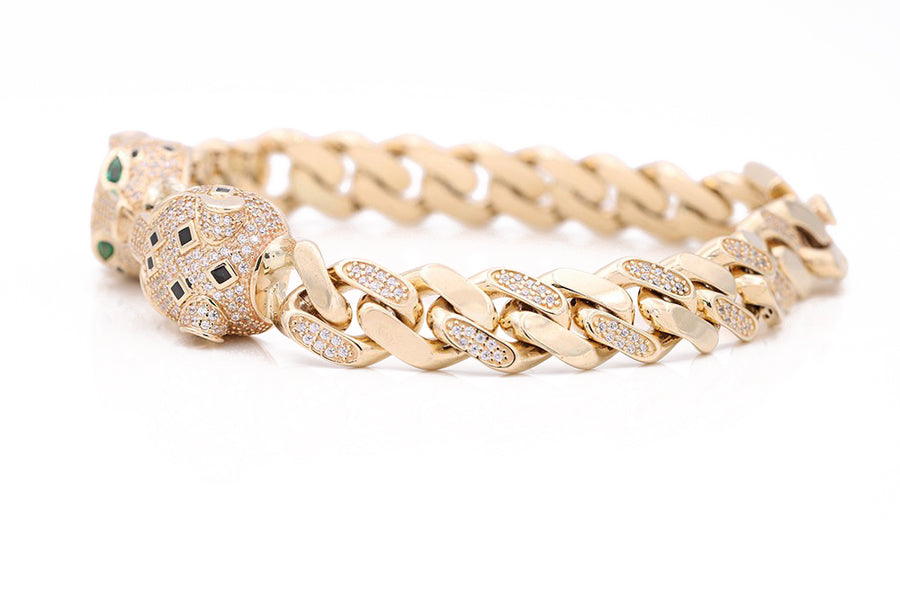 A men's Miral Jewelry yellow gold 14k fashion bracelet adorned with stunning emeralds and diamonds, perfect for adding a touch of fashion-forward luxury to any ensemble.